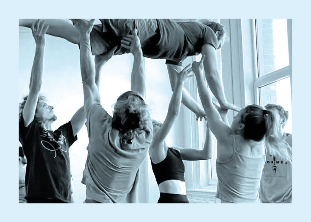 Entraînement en arts du cirque avec acrobatie collective et portés acrobatiques en studio lumineux